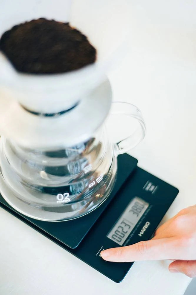 https://www.groundcoffeesociety.com/cdn/shop/files/ground-coffee-society-hario-V60drip-coffee-scale-product-in-use-2.webp?v=1696043350&width=666